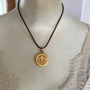 Vintage gold charm on brown leather cord